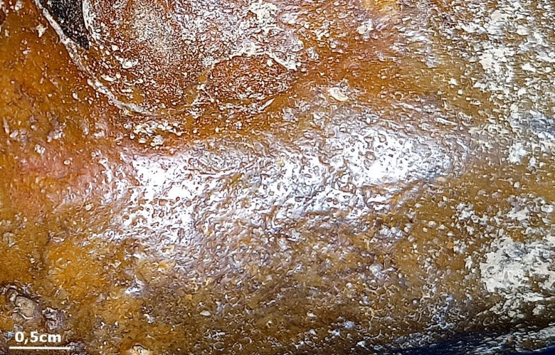 Detail van putjes in een vuursteenoppervlak; vergelijkingsbeeld van natuurlijke vuursteen.